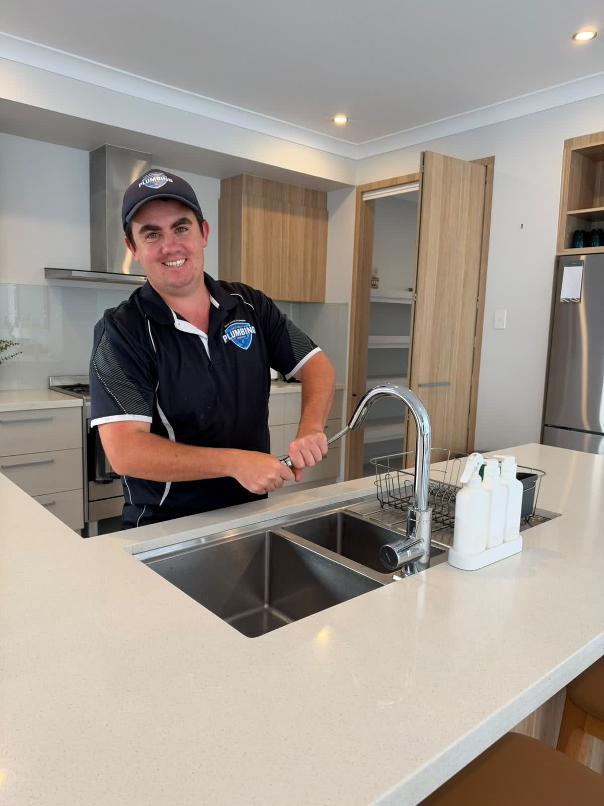 Gold Coast Plumbing plumber at a kitchen sink