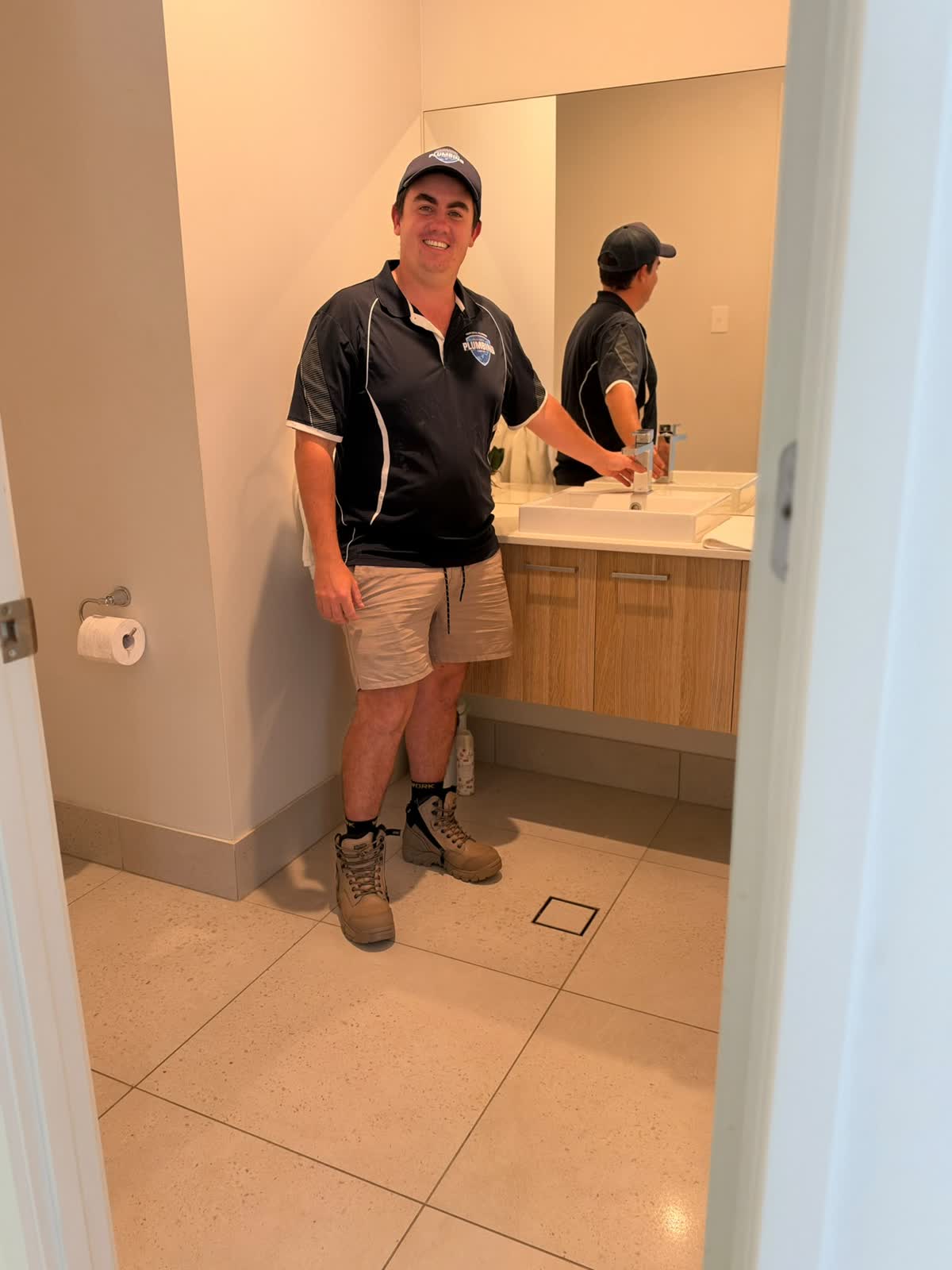 Gold Coast Plumbing plumber at a bathroom vanity